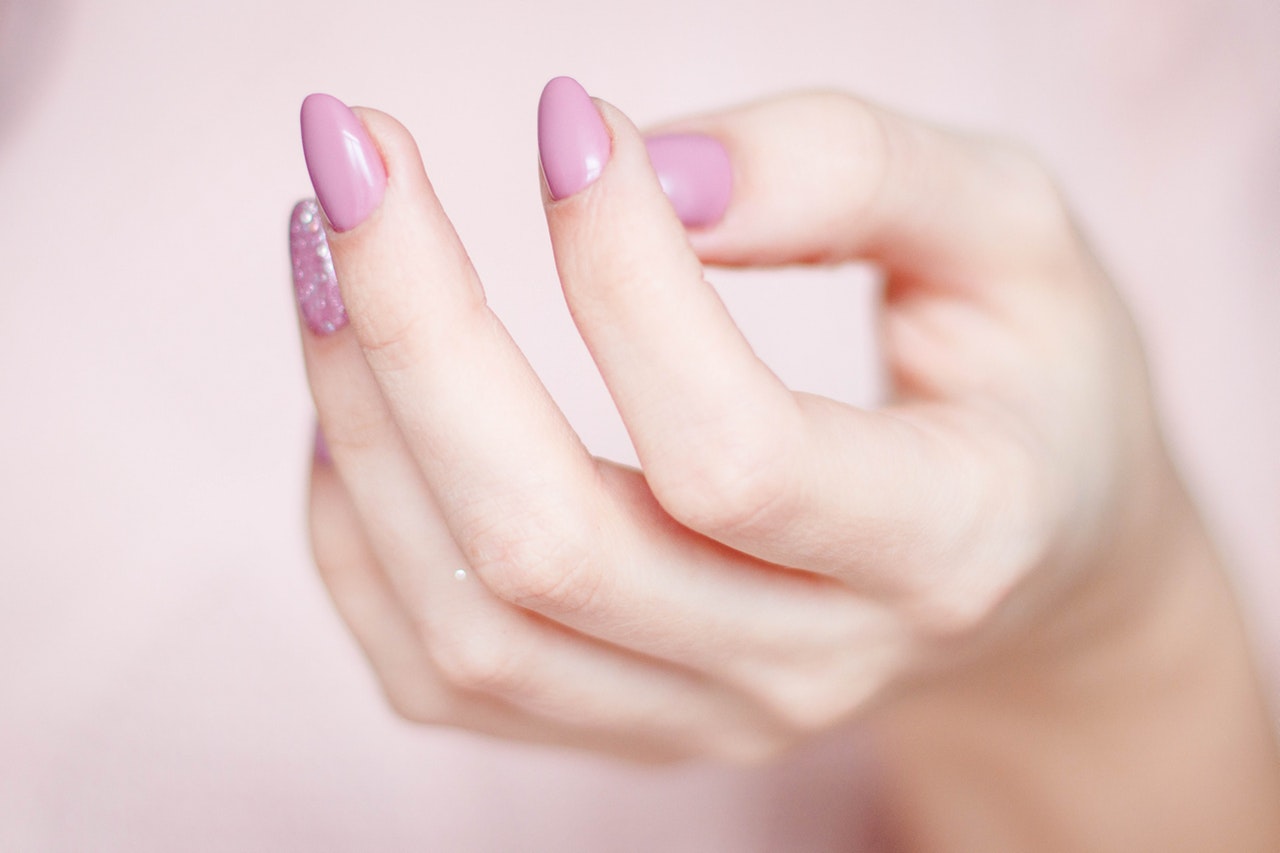 person-s-hand-with-pink-manicure-939835